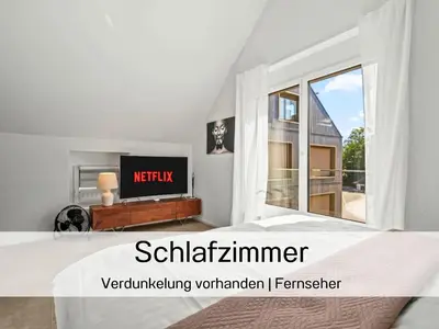 a bedroom with a bed and a large window at Ferienhausträume Bergstrasse Bodensee - inkl Tiefgarage, Garten und Dachterrasse in Kreuzlingen