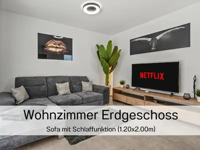 a living room with a couch and a tv at Ferienhausträume Bergstrasse Bodensee - inkl Tiefgarage, Garten und Dachterrasse in Kreuzlingen
