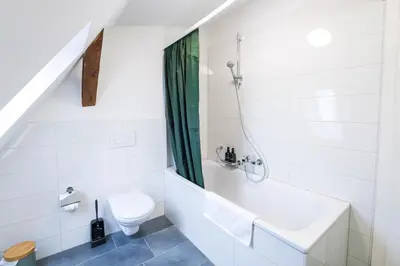 a bathroom with a tub and a toilet at Duplex Apartment - Lake Constance - Self Check-in - Parking - 4-Keys Apartments in Rorschach