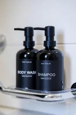 two bottles of soap and shampoo on a shelf at Duplex Apartment - Lake Constance - Self Check-in - Parking - 4-Keys Apartments in Rorschach
