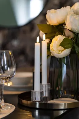 a table with two candles and a vase of flowers at Duplex Apartment - Lake Constance - Self Check-in - Parking - 4-Keys Apartments in Rorschach