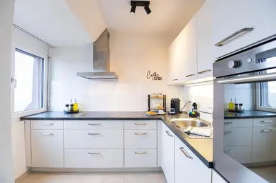 a kitchen with white cabinets and a sink at Duplex Apartment - Lake Constance - Self Check-in - Parking - 4-Keys Apartments in Rorschach