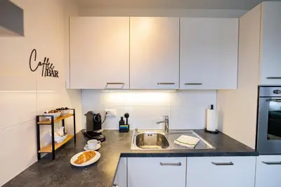 a kitchen with white cabinets and a sink at Duplex Apartment - Lake Constance - Self Check-in - Parking - 4-Keys Apartments in Rorschach