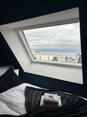 a bed in a room with a large window at Duplex Apartment - Lake Constance - Self Check-in - Parking - 4-Keys Apartments in Rorschach