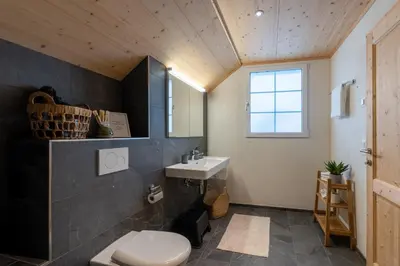 a bathroom with a white toilet and a sink at Ganzes Haus am Bodensee in den Bergen im Appenzell in Heiden