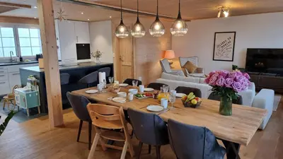a dining room and living room with a wooden table at Ganzes Haus am Bodensee in den Bergen im Appenzell in Heiden