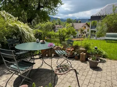 a patio with a table and chairs in a garden at 3 Zimmerwohnung mit Gartenterrasse, mitten im idyllischen Gais für 1 bis 3 Personen in Gais