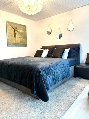 a bedroom with a bed with a blue comforter at Luxus Studio Apartment am Bodensee in Güttingen