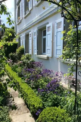 a garden in front of a house with purple flowers at Apartment Kleines Loft by Interhome in Gais