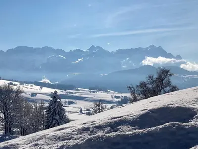 a snow covered hill with a mountain range in the background at Apartment Kleines Loft by Interhome in Gais