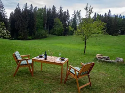 a wooden table and two chairs sitting in the grass at Holiday Home Fromsenrüti by Interhome in Walzenhausen