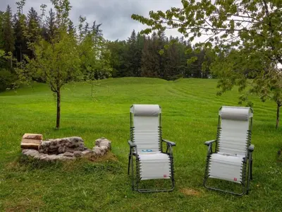 two chairs sitting in the grass near a fire pit at Holiday Home Fromsenrüti by Interhome in Walzenhausen