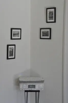 a white wall with four framed pictures and a basket on a table at Apartment Chäserruggblick by Interhome in Unterwasser