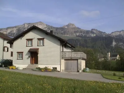 a white house with mountains in the background at Apartment Sutter in Brülisau bei Appenzell by Interhome in Brülisau