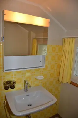 a bathroom with a sink and a mirror at Apartment Sutter in Brülisau bei Appenzell by Interhome in Brülisau