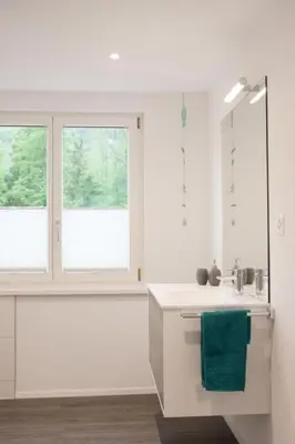 a white kitchen with a sink and two windows at Apartment Ferien im Toggenburg by Interhome in Krummenau