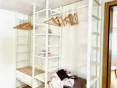 a white closet with wooden shelves and shoes at Apartment im Dorf Urnäsch by Interhome in Urnäsch