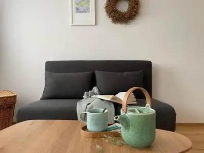 a living room with a couch and a table with mugs at Apartment im Dorf Urnäsch by Interhome in Urnäsch