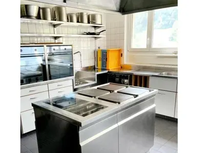 a kitchen with stainless steel appliances and white cabinets at Holiday Home Ski- und Gruppenhaus by Interhome in Alt Sankt Johann