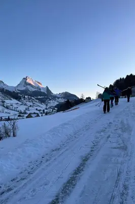 a group of people walking down a snow covered road at Holiday Home Ski- und Gruppenhaus by Interhome in Alt Sankt Johann