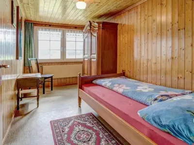 a bedroom with a bed and a desk and a window at Apartment Hautle by Interhome in Appenzell Innerrhoden