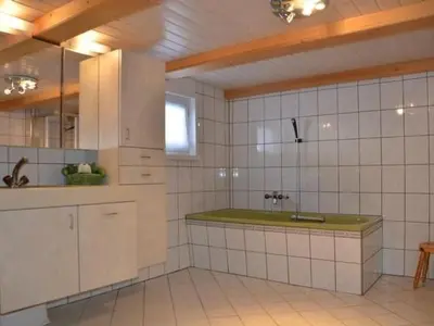 a kitchen with a sink and white tiled walls at Apartment Breiten by Interhome in Brunnadern