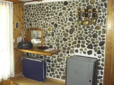 a room with a stone wall with a mirror and a television at Apartment Bijou by Interhome in Alt Sankt Johann