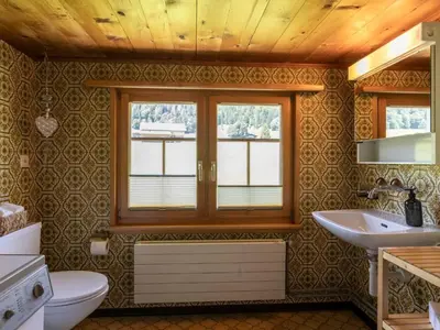 a bathroom with a toilet and a sink and a window at Apartment by Interhome in Unterwasser