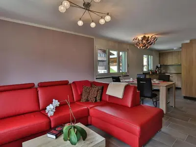 a living room with a red couch and a kitchen at Apartment Weiherhof by Interhome in Wildhaus