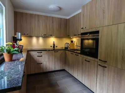 a kitchen with wooden cabinets and a sink and a microwave at Apartment Weiherhof by Interhome in Wildhaus