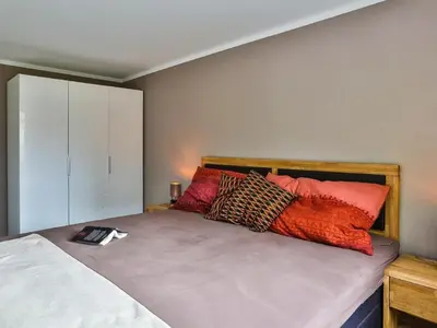 a bedroom with a bed with a book on it at Apartment Weiherhof by Interhome in Wildhaus