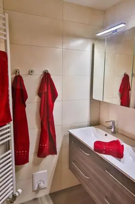 a bathroom with red robes on the wall and a sink at Apartment Weiherhof by Interhome in Wildhaus