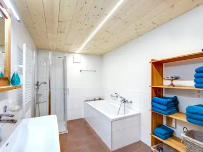 a bathroom with a tub and a shower and a sink at Apartment Bauernhof Fendrig - neue Wohnung by Interhome in Haslen