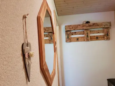 a mirror hanging on a wall with a wooden frame at Apartment Ferien im Gugger - Wohnung Stockberg by Interhome in Nesslau