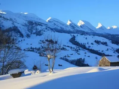 a tree in the snow with mountains in the background at Apartment Casa Uccello by Interhome in Wildhaus