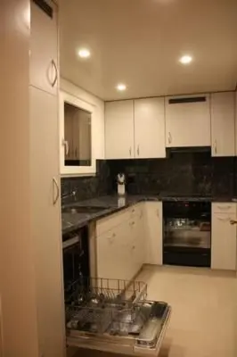 a kitchen with white cabinets and black counter tops at Apartment Casa Uccello by Interhome in Wildhaus