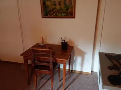 a wooden table with a chair and a picture on the wall at Holiday Home Ferien in der Vogelherd by Interhome in Wolfhalden