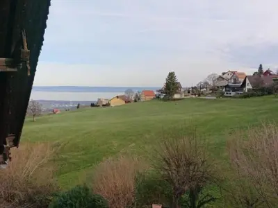 a large green field with houses and the ocean at Holiday Home Ferien in der Vogelherd by Interhome in Wolfhalden