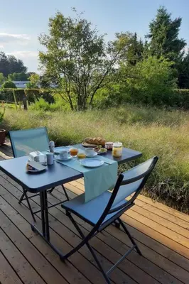 a picnic table with two chairs and food on a deck at Holiday Home Gartenbungalow 2 - 3 Personen by Interhome in Arbon