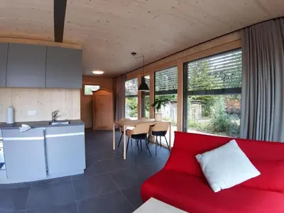 a living room with a red couch and a kitchen at Holiday Home Gartenbungalow 2 - 3 Personen by Interhome in Arbon