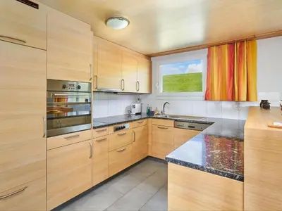 a kitchen with wooden cabinets and a window at Apartment Hof Höchi by Interhome in Bruggen