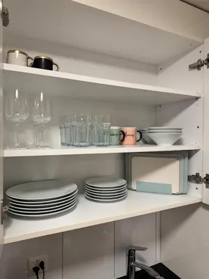 a kitchen with plates and glasses on a shelf at McNeal Solutions Zentrale Lage direkt am Roten Platz in St. Gallen