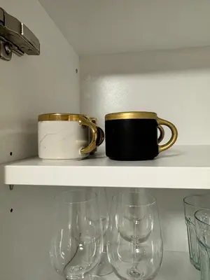 a shelf with two glasses and a pot and glasses at McNeal Solutions Zentrale Lage direkt am Roten Platz in St. Gallen