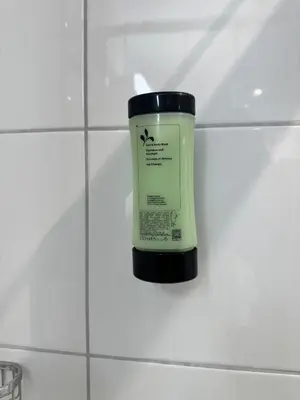 a bottle of moisturizing cream sitting on a bathroom tile wall at McNeal Solutions Zentrale Lage direkt am Roten Platz in St. Gallen