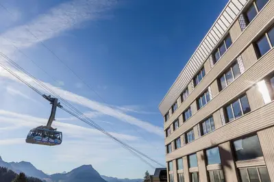 a gondola is in the air above a building at Säntis - das Hotel in Schwagalp