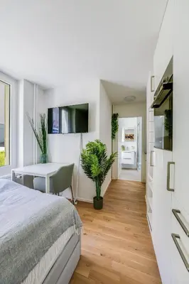 a bedroom with a bed and a desk and a table at Urban Hideaway Studio St Gallen Center in St. Gallen