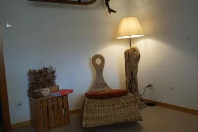 a room with a chair and a lamp and a table at Naturnah und familienfreundlich in Degersheim