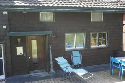 two blue chairs sitting outside of a house at Naturnah und familienfreundlich in Degersheim