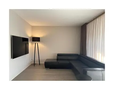 a living room with a couch and a television at Zuhause am Bodensee in Bottighofen