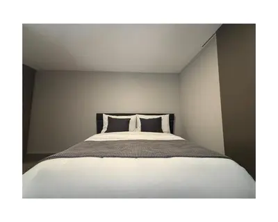a bedroom with a white bed with two pillows at Zuhause am Bodensee in Bottighofen